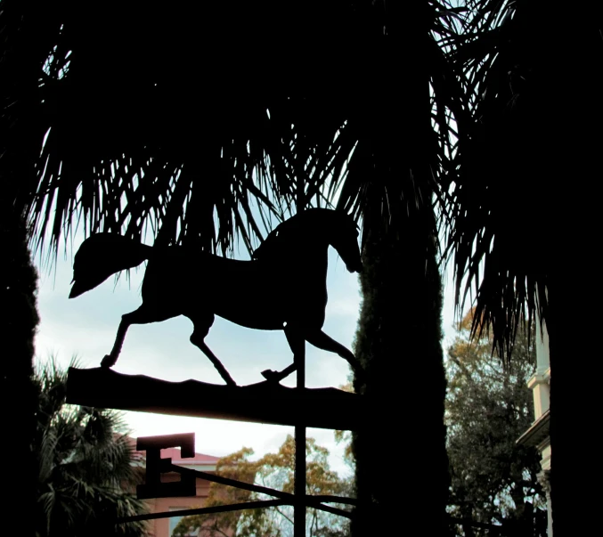 a figurine of a horse is shown on a palm tree