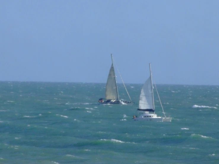 two boats in the middle of an ocean with waves