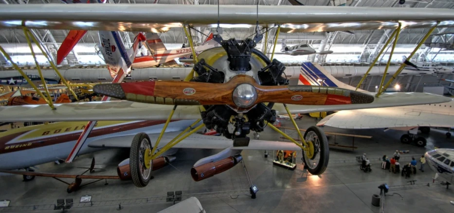 a propeller plane inside of a building with many people around