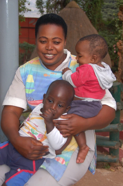 a woman sitting on top of a chair holding a baby