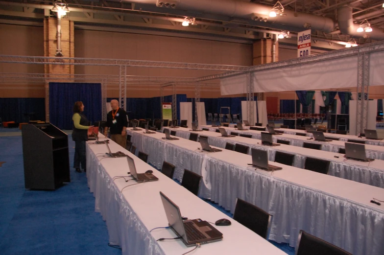 a room with tables covered in white tablescloths