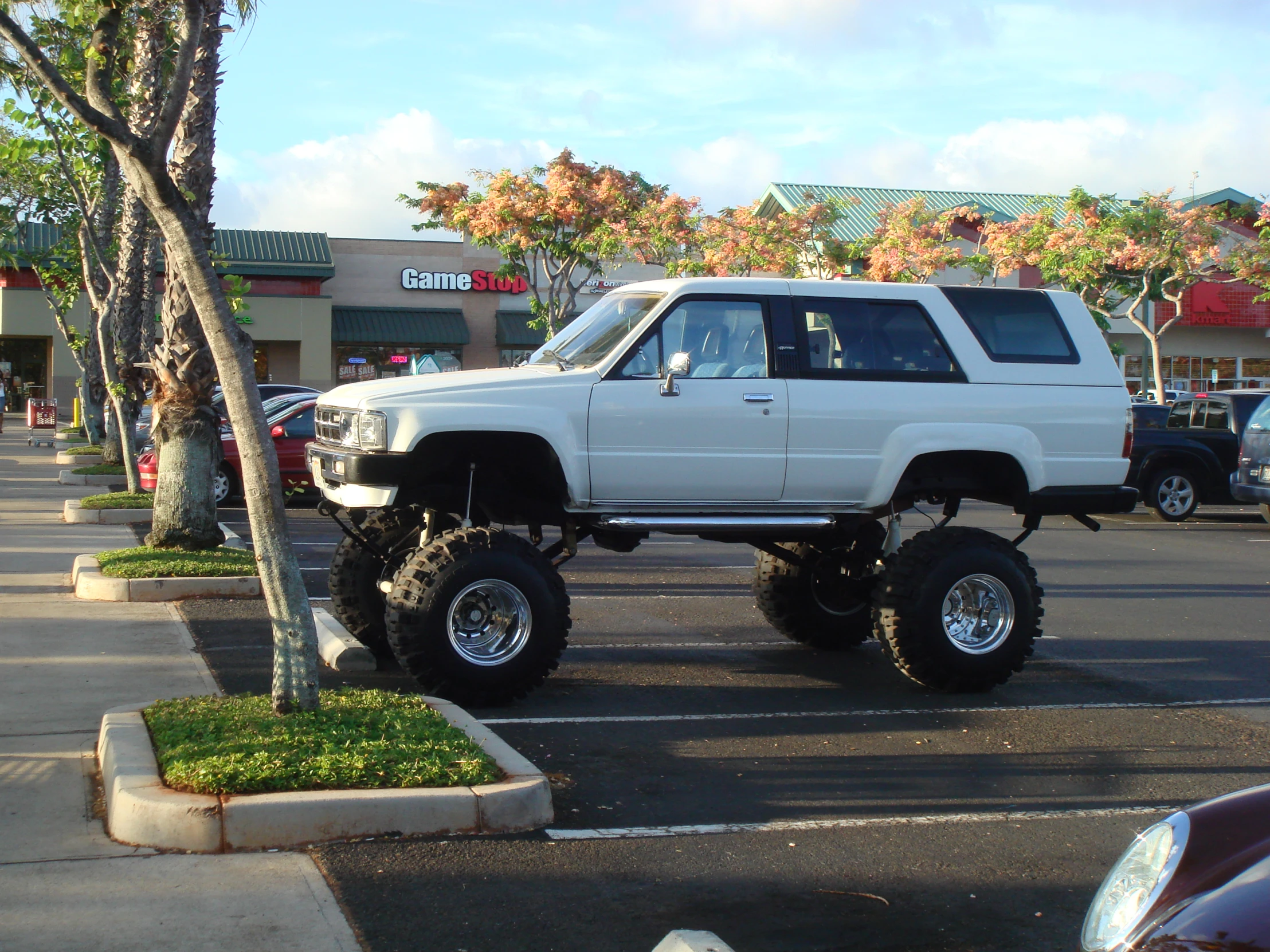 this white truck is big and heavy in a parking lot