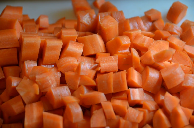 a pile of cut up carrots sitting on top of a  board