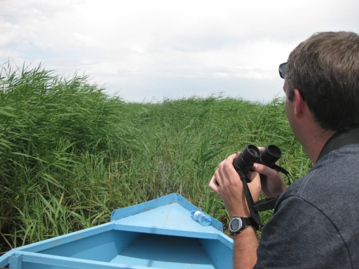 a man standing in front of a boat holding a camera