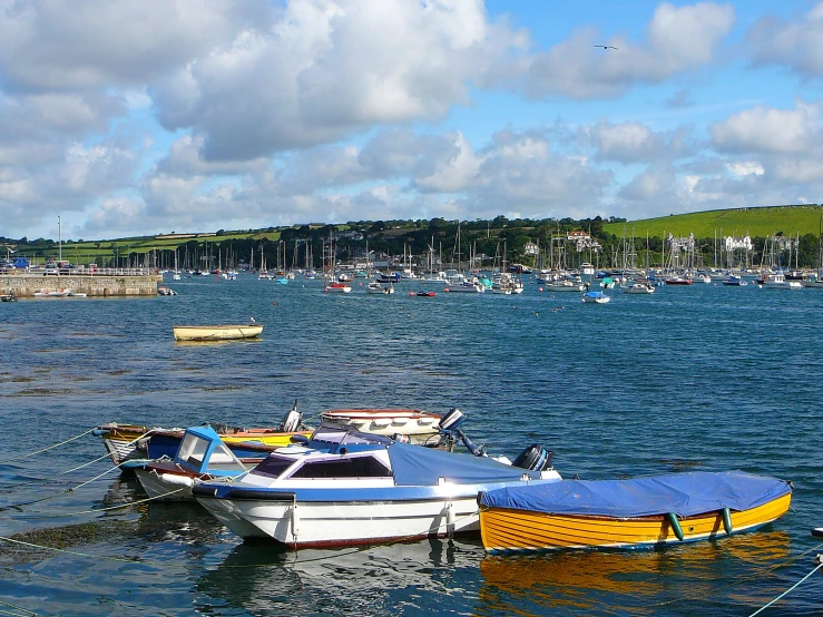 a group of colorful boats floating in water near a shoreline