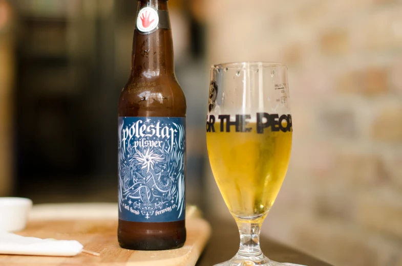 a bottle of beer sits beside a glass on a table