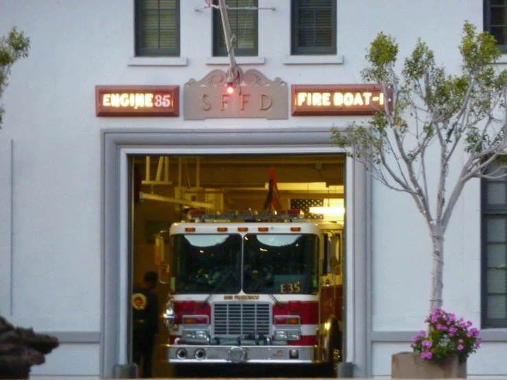 a fire truck parked in front of the entrance to a white building