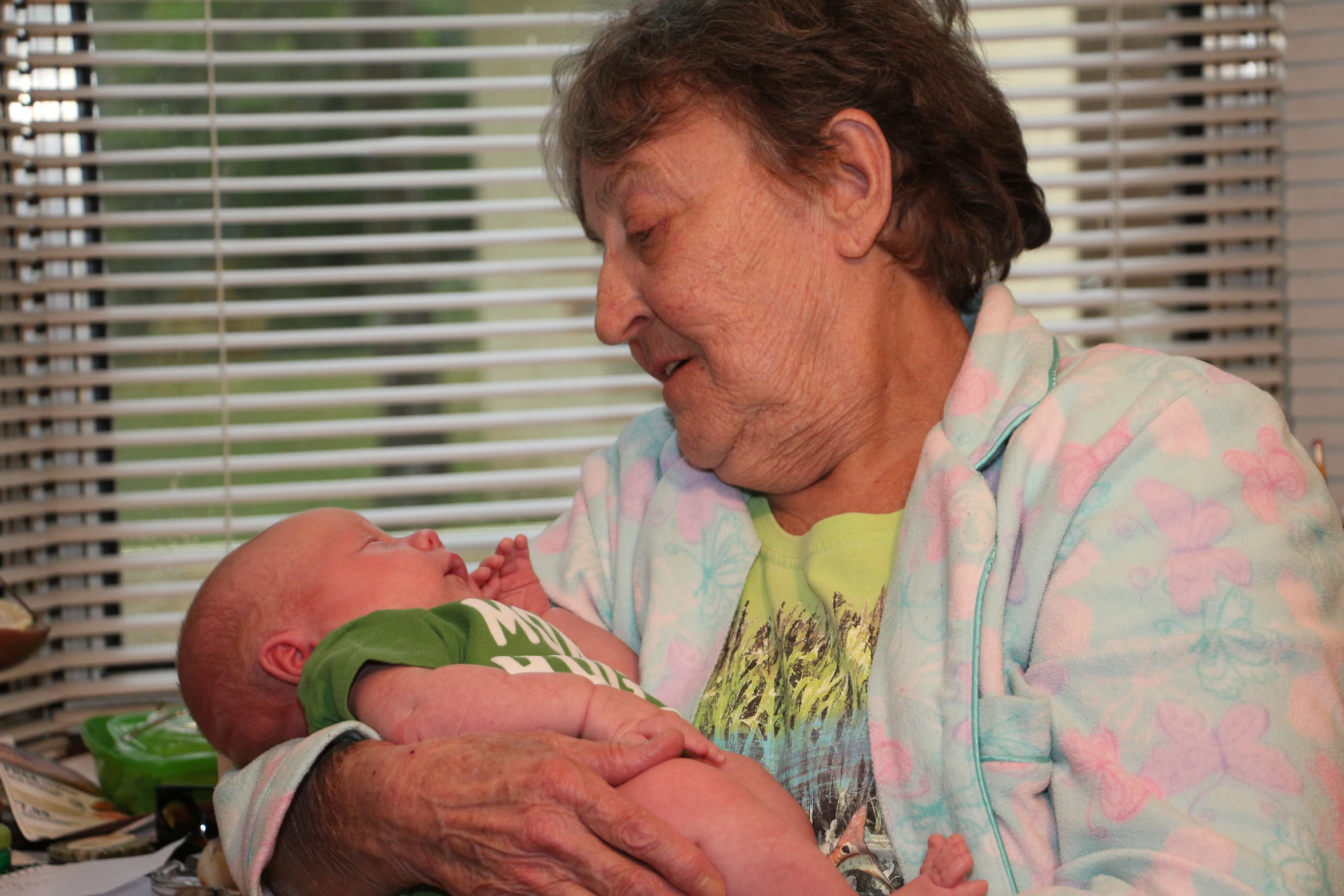 an older woman holds a newborn baby in her hands