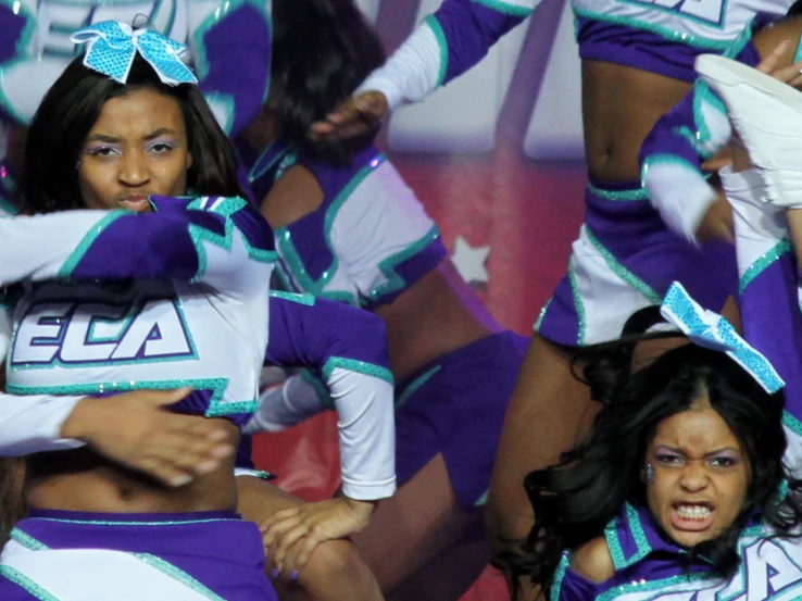 dancers in various purple outfits pose for a picture