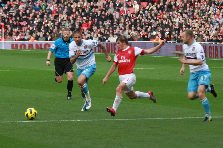 two soccer players are chasing the ball while two players are on opposite teams