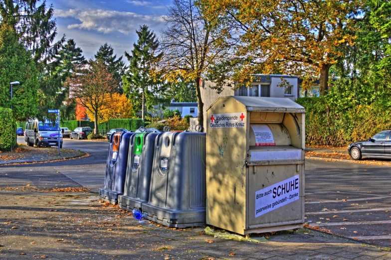 a number of trash cans and dumpsters on the sidewalk