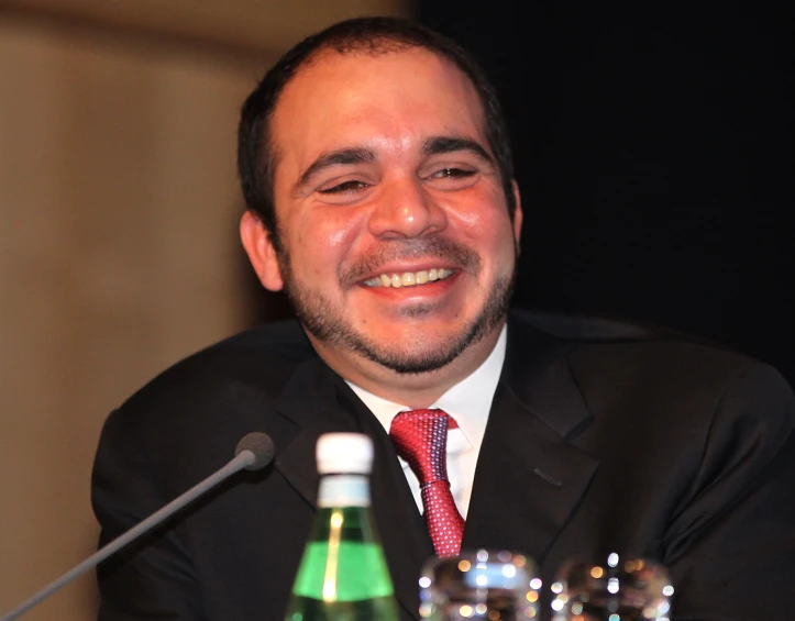 a man in suit and tie sitting at a table