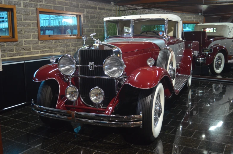 a vintage red car is parked inside of a building