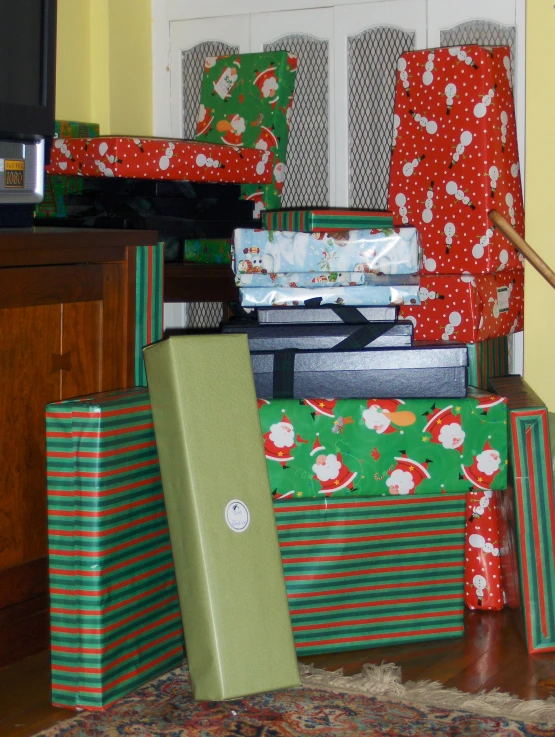 a bunch of wrapped gifts next to some kind of tv