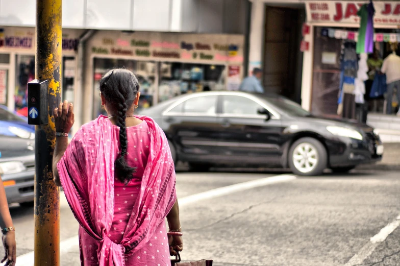 a woman in pink walks down the street