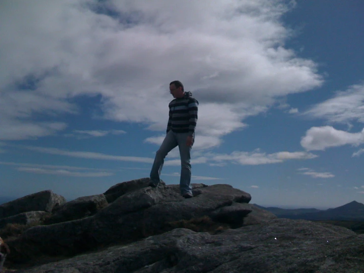 a man stands on top of rocks on a mountain