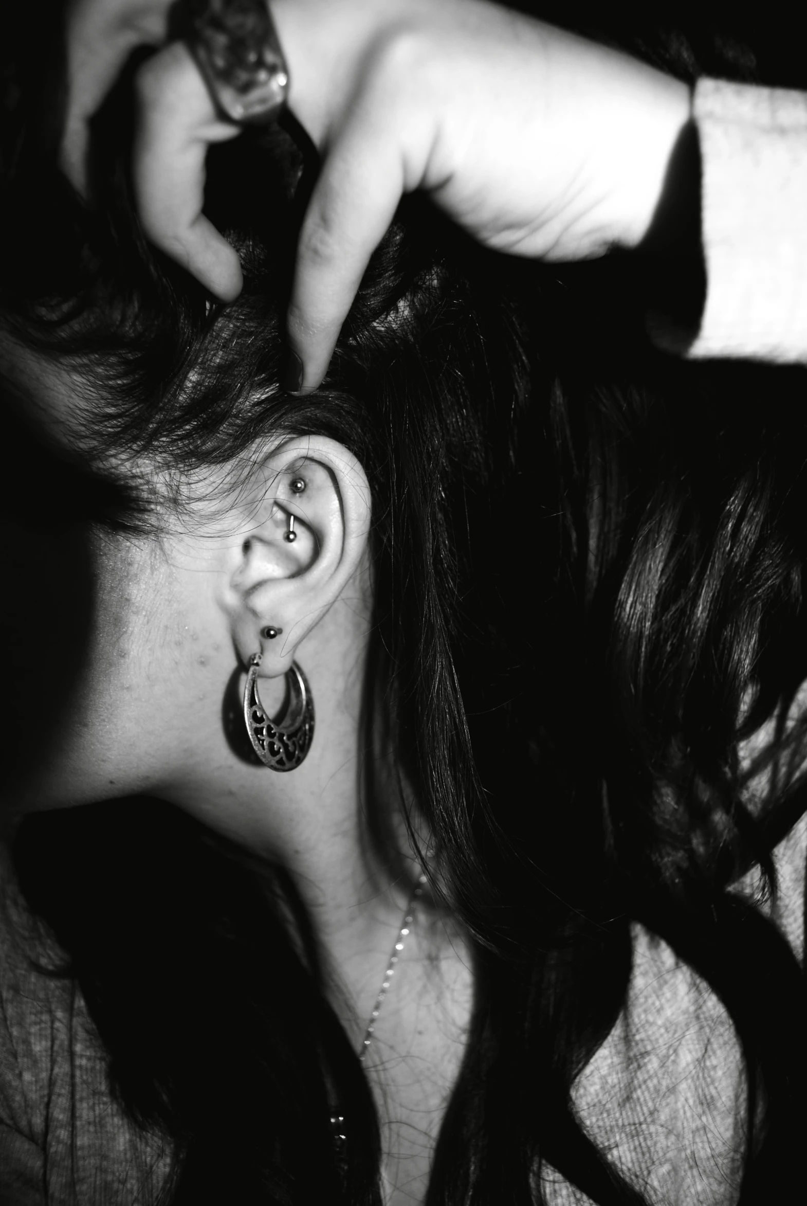 the woman is putting ear rings on her ear