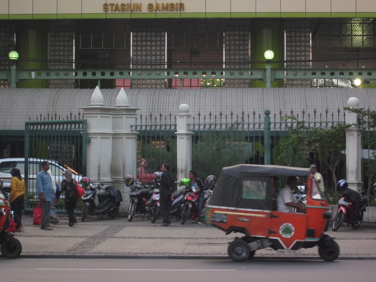 people on motorized vehicles in front of buildings