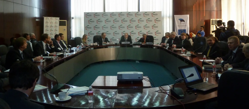 a group of people sitting at a big conference table