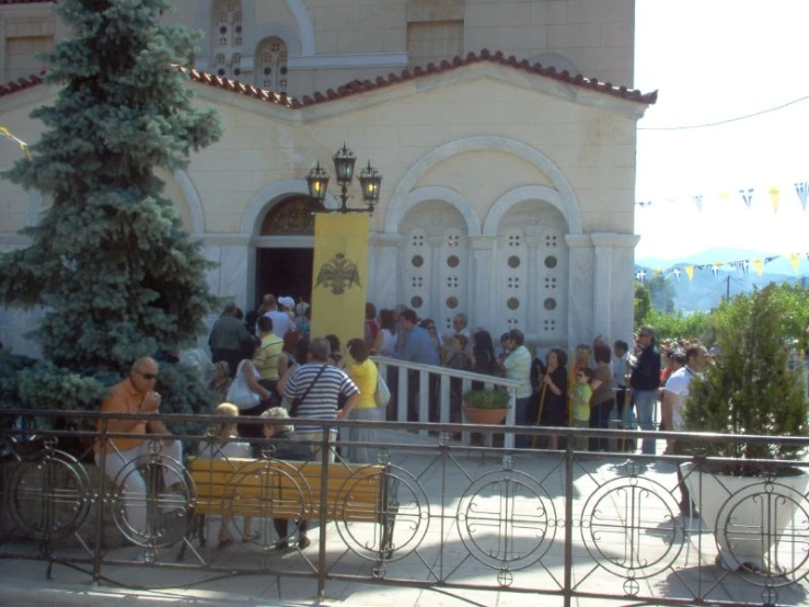 several people are waiting in front of a house to get on a bike