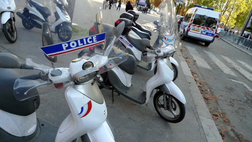 a line of police scooters parked on the side of the road