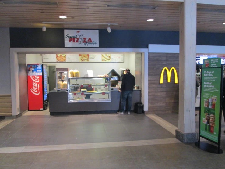 the man is standing in front of a mcdonald's counter