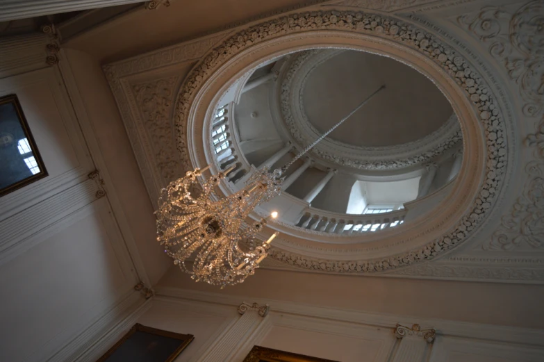 a circular chandelier hangs from the ceiling inside of a building