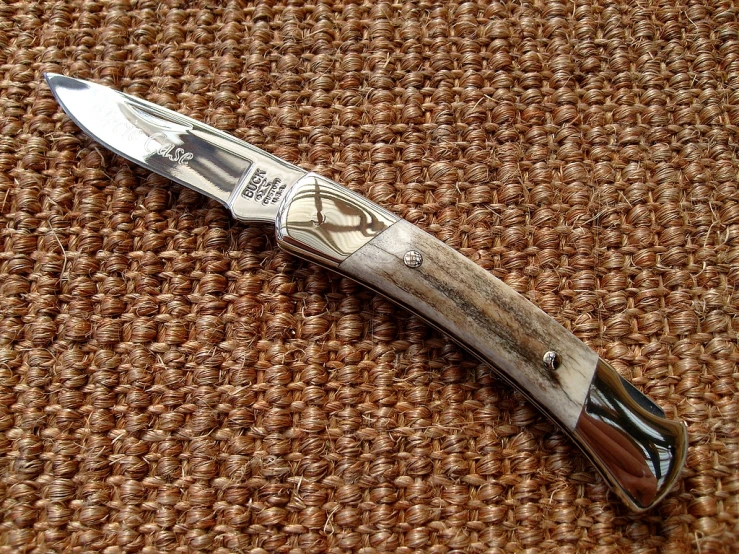 a close up view of a knife that is laying on the cloth