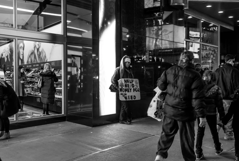 black and white image of people walking near the entrance of a store