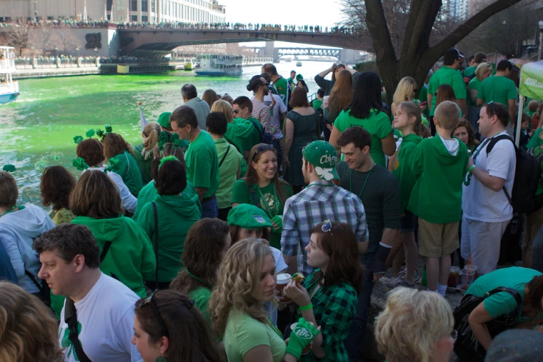 a group of people with green shirts are on a river