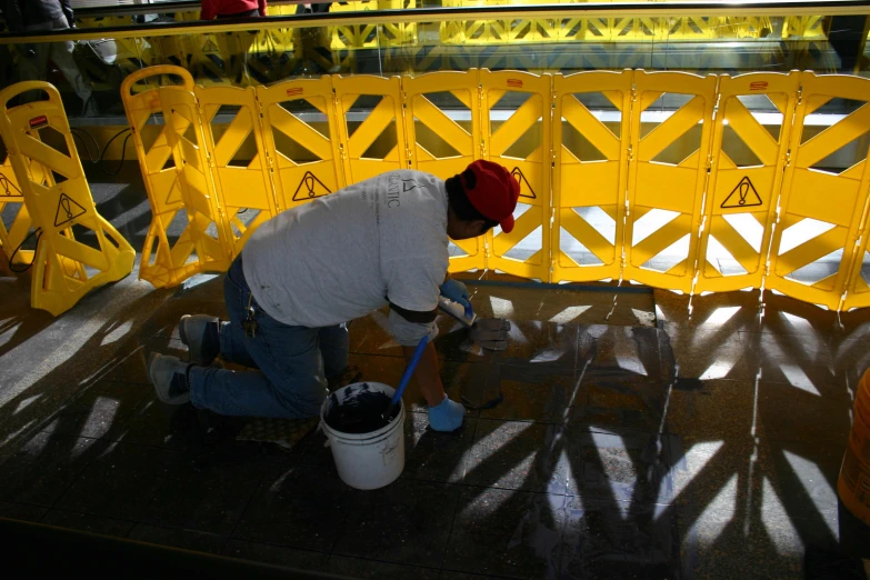 a man working on some yellow plastic construction