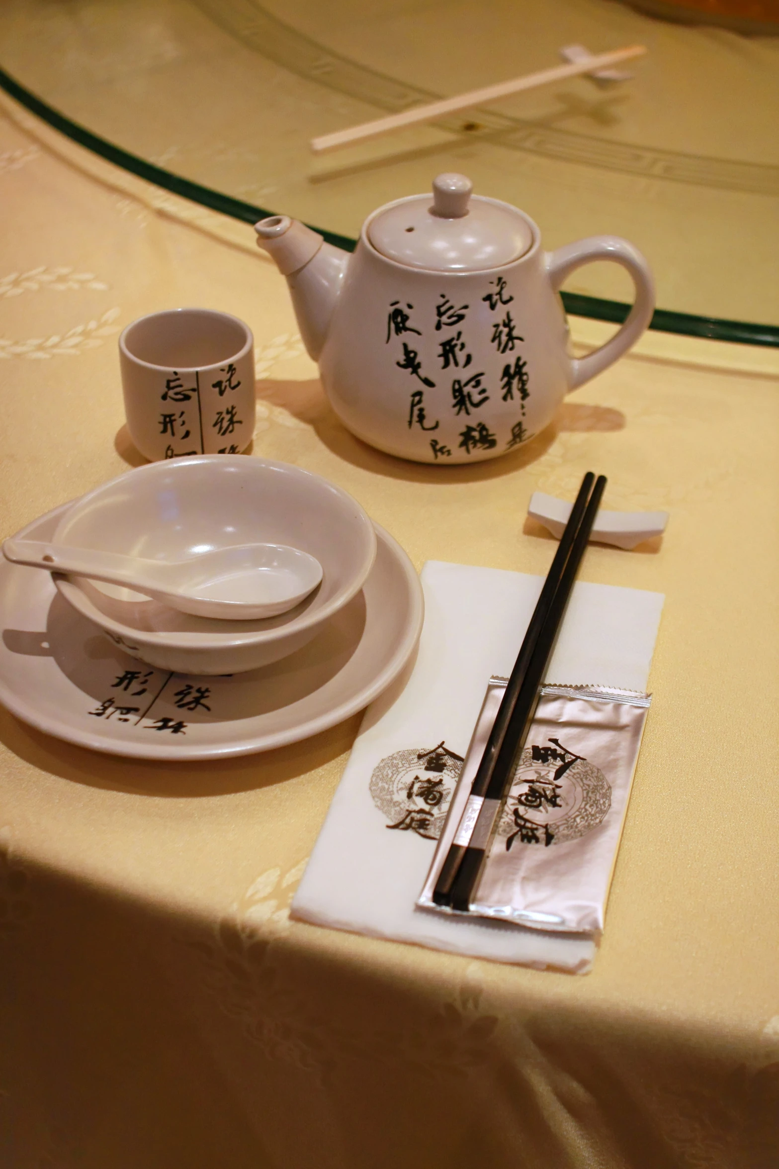 a table with two plates, coffee pot and a pen