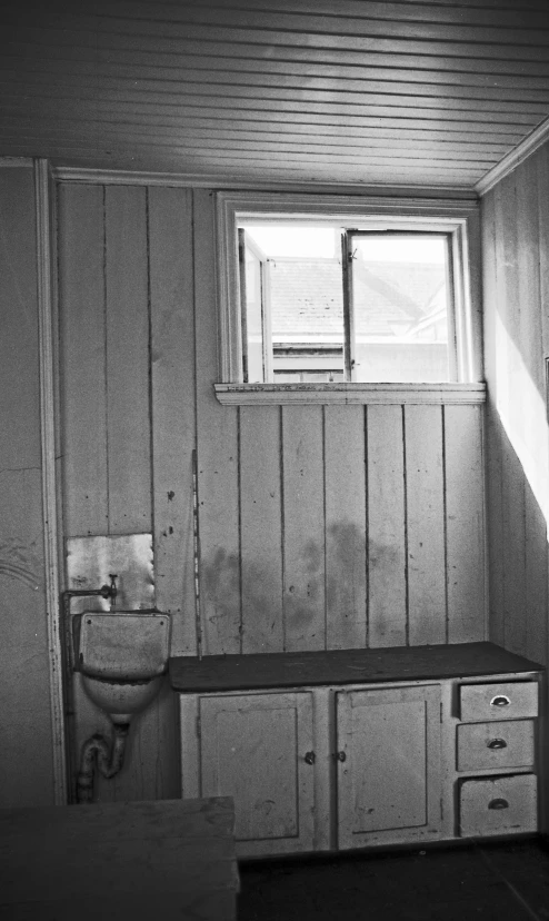 a wooden cabin with white cabinets, a sink and a toilet