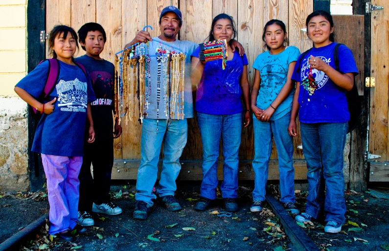 six people pose with beaded beads around their necks
