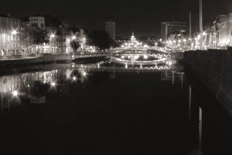 a canal and a bridge in a city at night