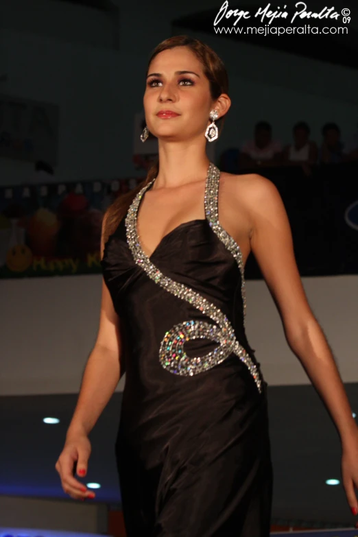 a woman on a runway wearing an evening gown