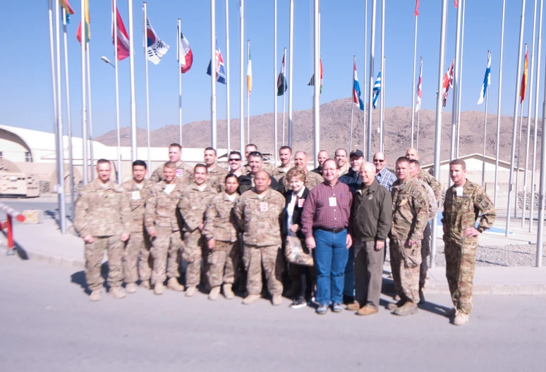 some soldiers standing in front of flags and poles