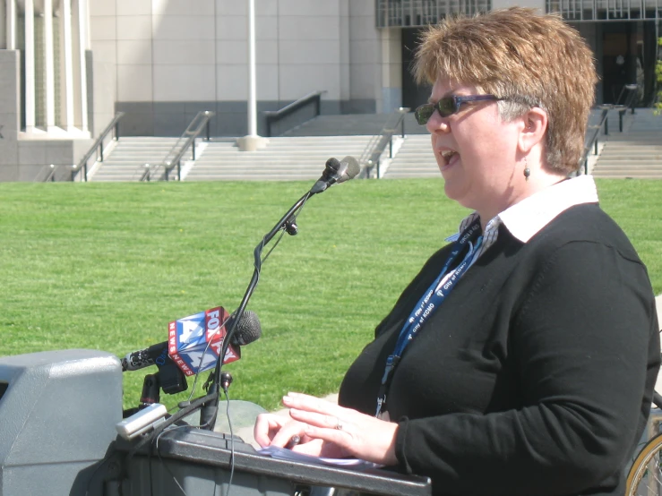 a woman in a wheelchair talking into microphone