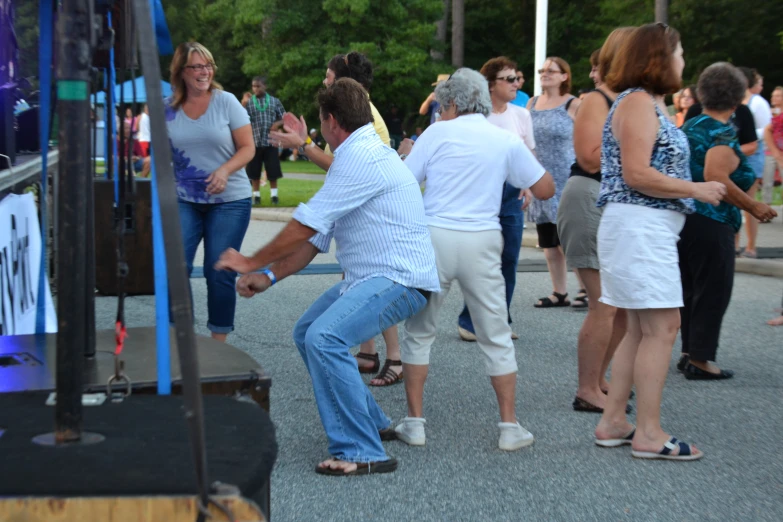 a bunch of people are gathered around a man who is trying to stand up