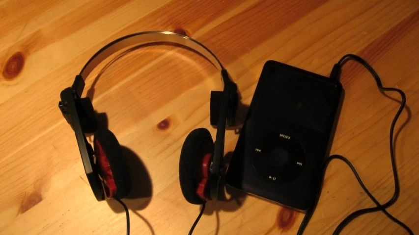 a pair of headphones and a ipod laying next to each other