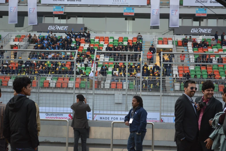 people standing on side of fence watching soccer match