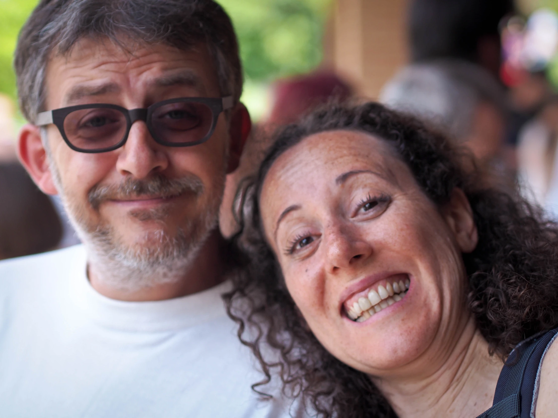 a woman with her arm around a man with glasses