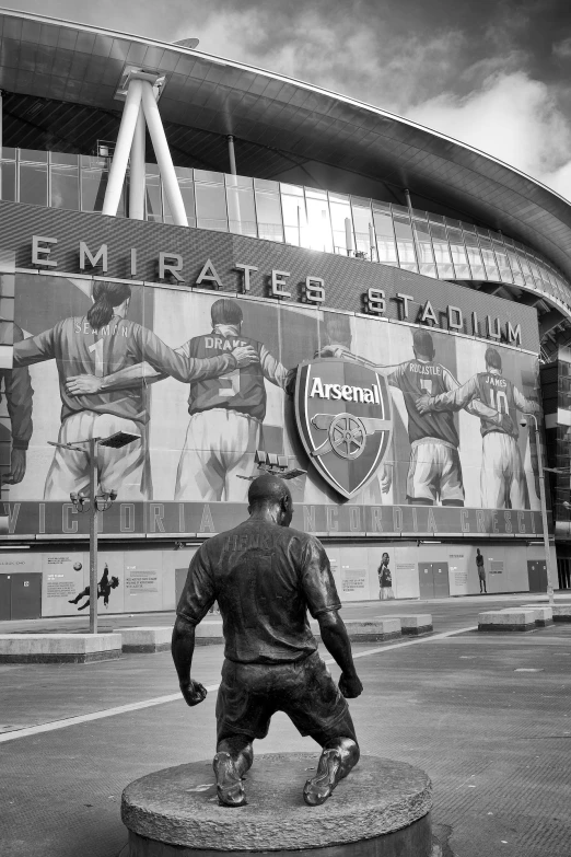 a statue of a football player in front of a stadium