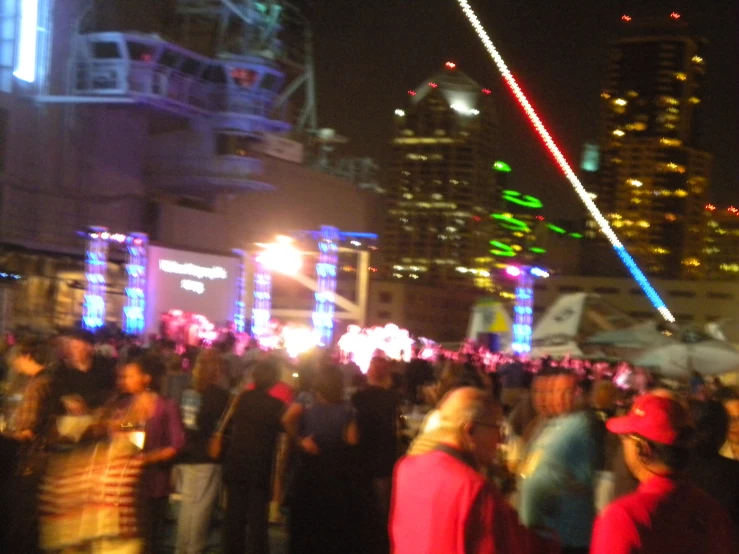 crowd of people standing in the street at night