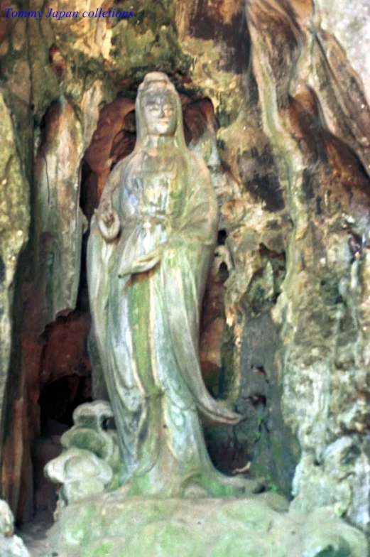 a statue is next to some trees and rocks