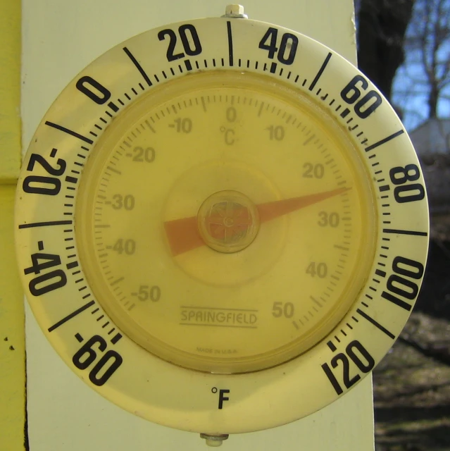 a yellow dial that reads 40 - 100 in front of a house