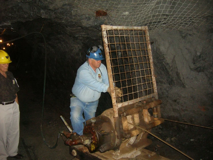 man and woman stand in a large rock tunnel