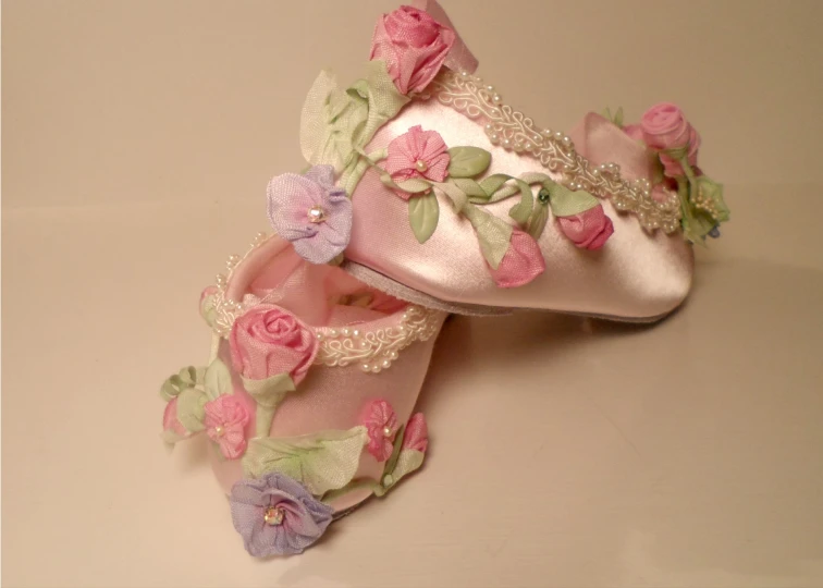 a pair of ballet shoes with pink and lavender flowers on them
