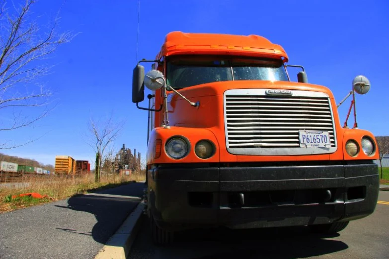 an orange truck is parked on the road