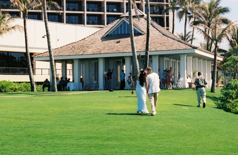 a couple of people walking through the grass